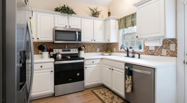 A kitchen with white cupboards and stainless steel appliances.