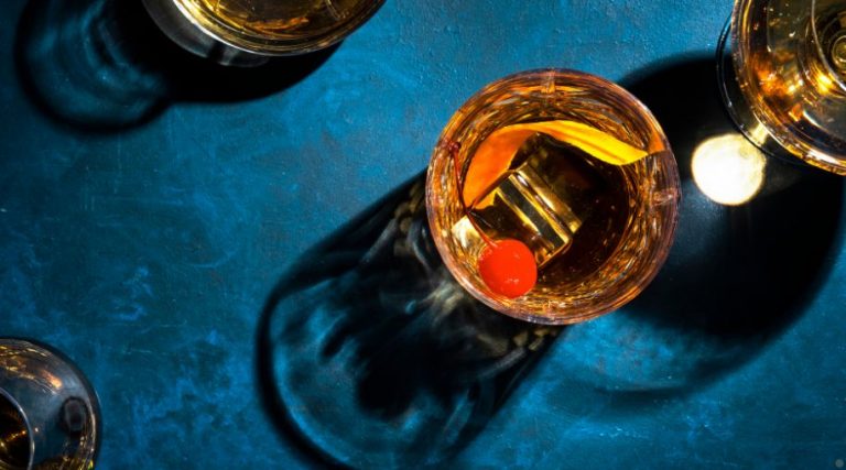 Bourbon cocktails on a blue table.