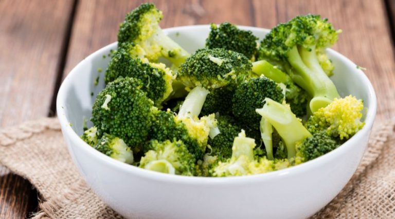 A white bowl full of broccoli.